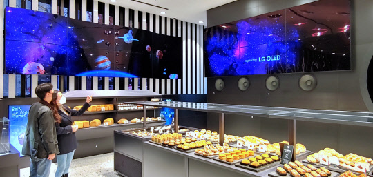 LG전자는 신세계푸드와 협력해 서울 청담동 소재 프리미엄 베이커리 '유니버스 바이 제이릴라'에 차별화된 성능과 디자인의 올레드(OLED) 디스플레이를 활용한 '올레드 월'을 설치했다고 9일 밝혔다. <LG전자 제공>